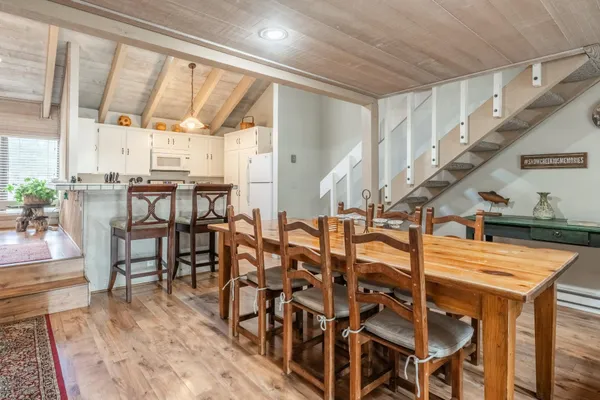 a dining room with lots of furniture and a painting