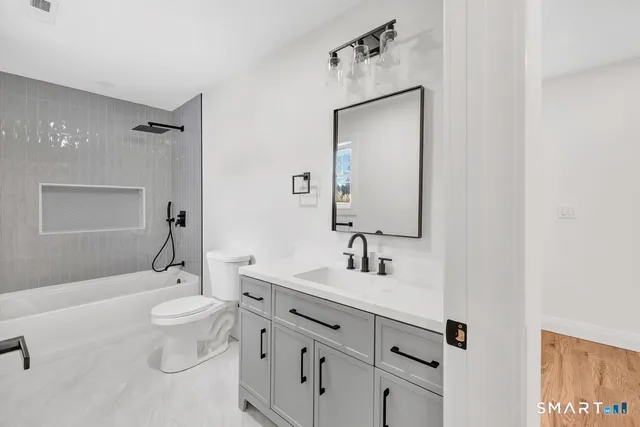 a bathroom with a sink toilet tub and shower