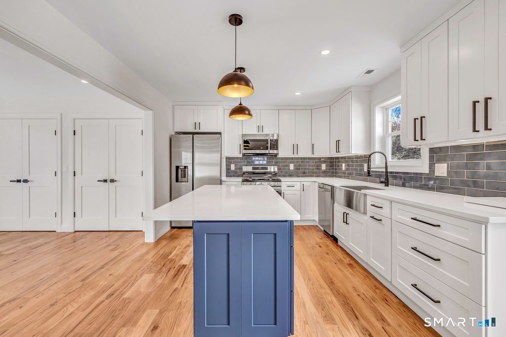 100 Tashua Road Trumbull, CT 06611 - Photo 8 of 26 a kitchen with stainless steel appliances granite countertop a sink dishwasher a stove and white cabinets with wooden floor