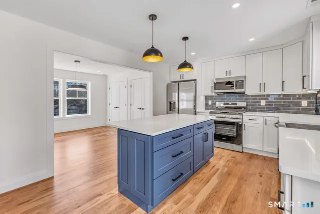 a kitchen with wooden floors and white cabinets