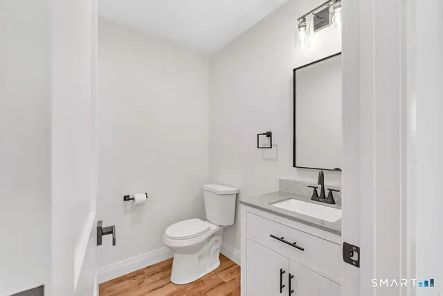 a bathroom with a granite countertop toilet sink and mirror