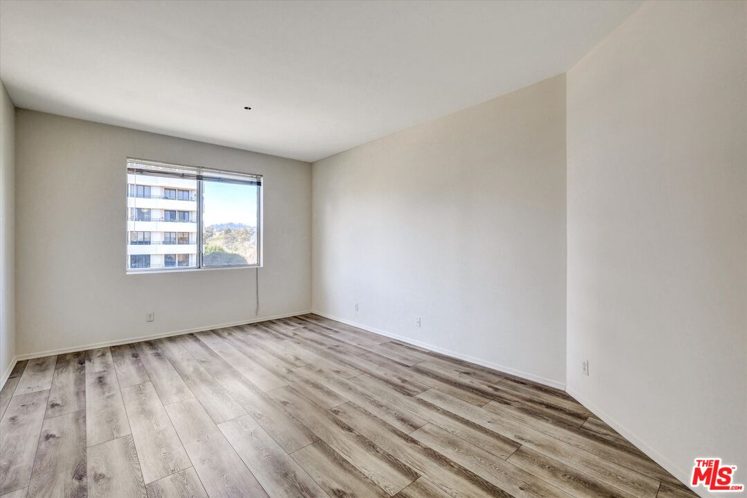 10600 Wilshire Boulevard, Unit 519 Los Angeles, CA 90024 - Photo 13 of 27 an empty room with wooden floor cabinet and windows