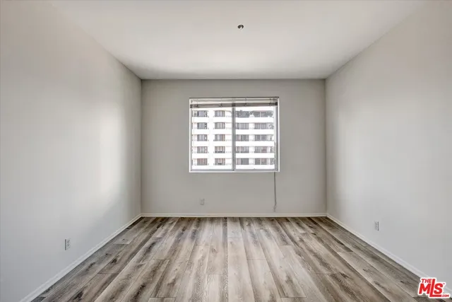 a view of a room with wooden floor and window