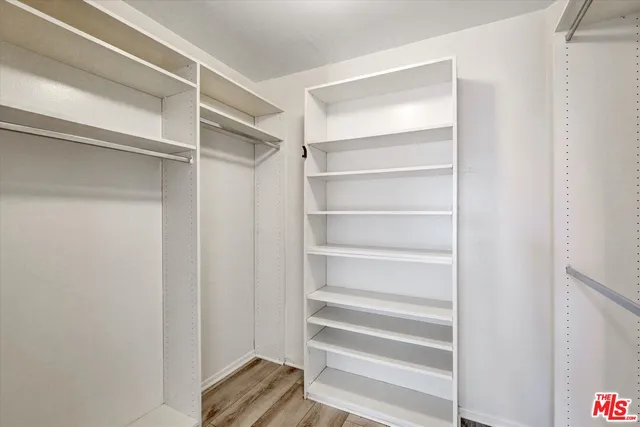 a view of walk in closet with empty racks