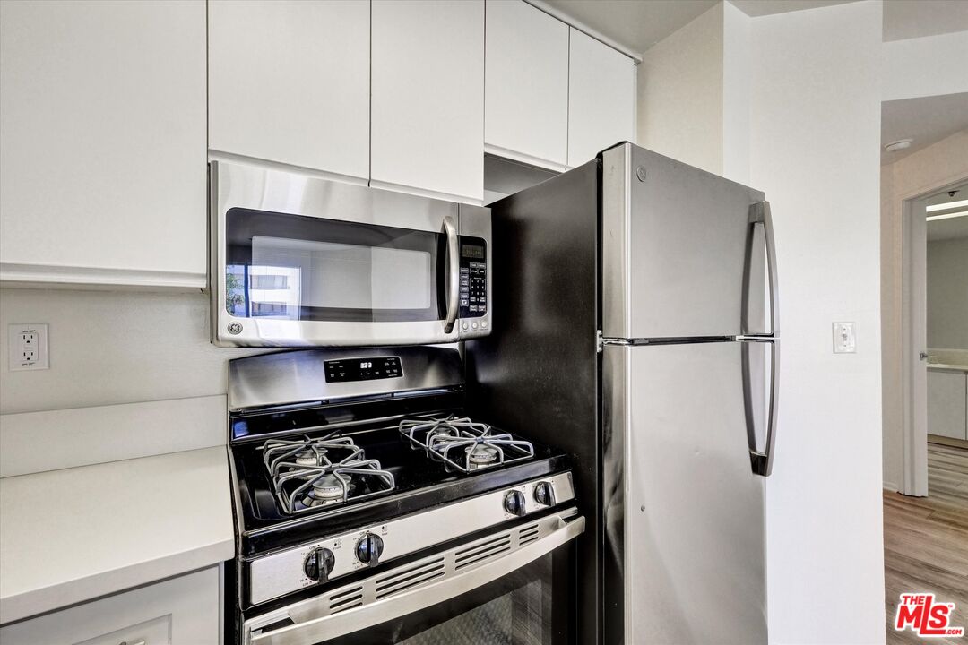 10600 Wilshire Boulevard, Unit 519 Los Angeles, CA 90024 - Photo 5 of 27 a kitchen with a stove and a microwave