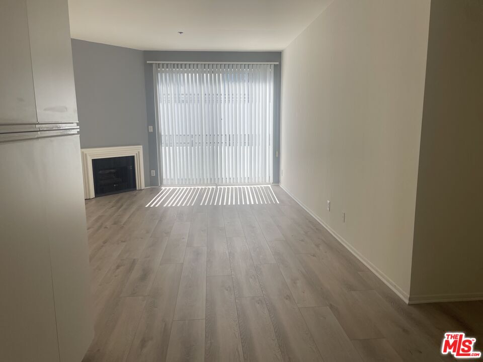 10600 Wilshire Boulevard, Unit 519 Los Angeles, CA 90024 - Photo 6 of 27 a view of empty room with wooden floor and fireplace