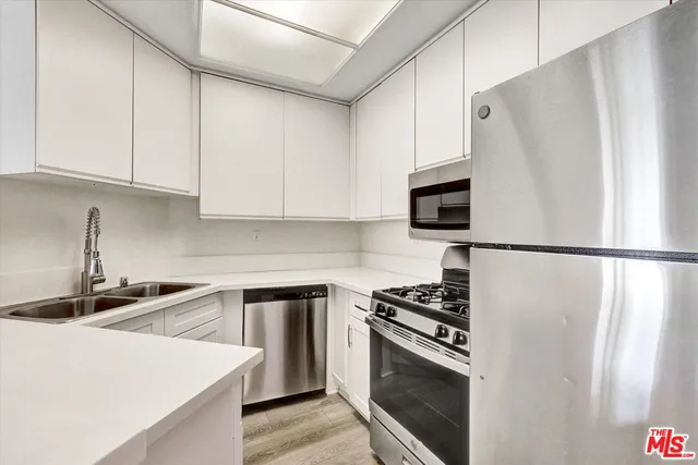 a kitchen with stainless steel appliances a refrigerator sink and microwave