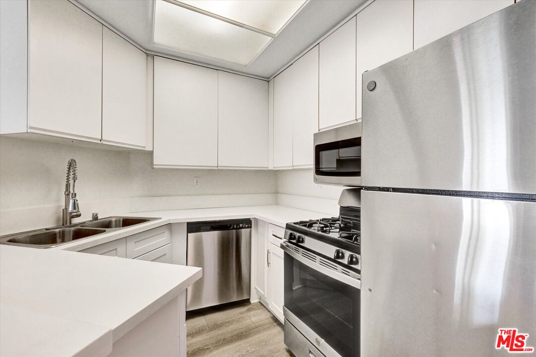 10600 Wilshire Boulevard, Unit 519 Los Angeles, CA 90024 - Photo 10 of 27 a kitchen with stainless steel appliances a refrigerator sink and microwave