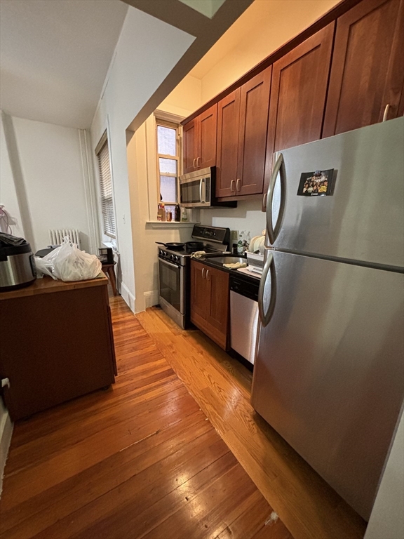 24 Peterborough Street, Unit 8 Boston, MA 02215 - Photo 3 of 9 a kitchen with stainless steel appliances granite countertop a refrigerator a stove a sink dishwasher and a refrigerator