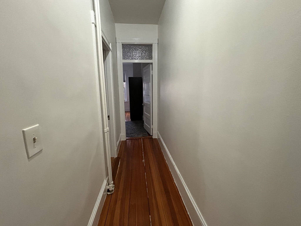 24 Peterborough Street, Unit 8 Boston, MA 02215 - Photo 4 of 9 a view of a hallway with wooden floor and a ceiling fan