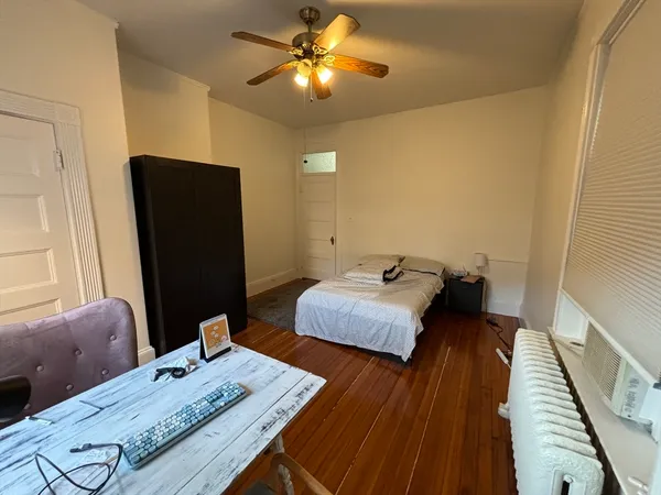 a bedroom with bed and wooden floor