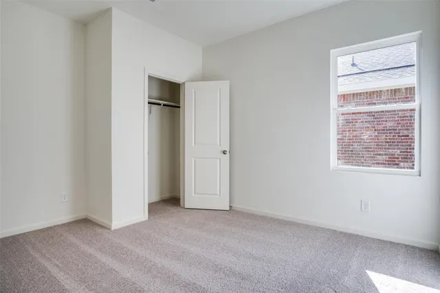 an empty room with closet and a bathroom