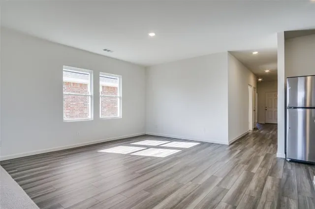 an empty room with wooden floor and a window