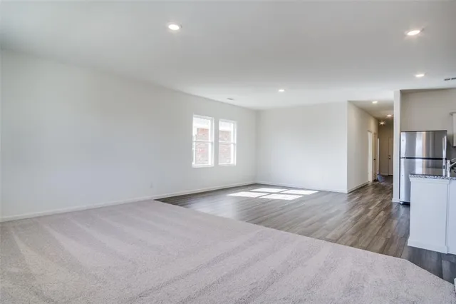 an empty room with wooden floor and window