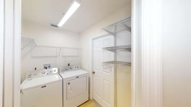 a view of an empty room with wooden floor and window