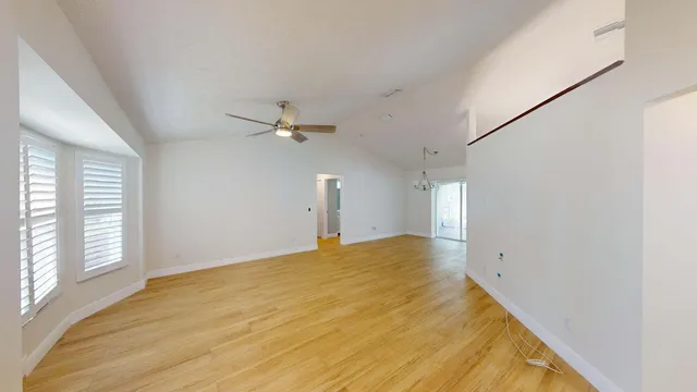 a large kitchen with kitchen island a large window a sink and white stainless steel appliances