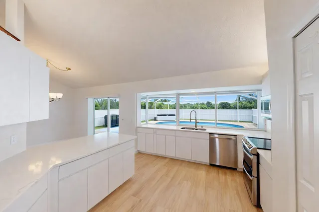 a kitchen with a sink a refrigerator and wooden floor