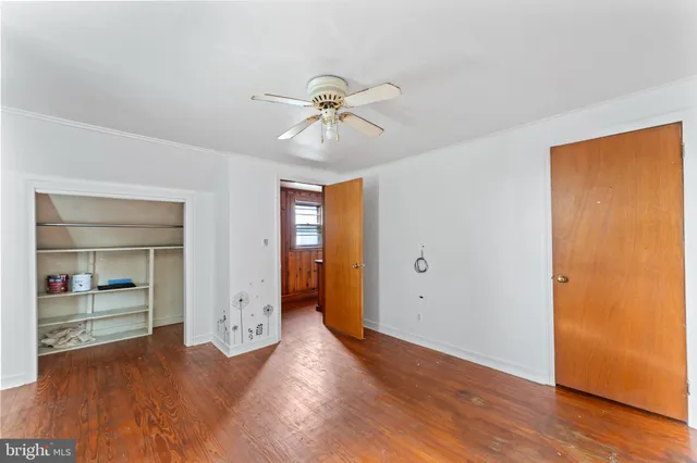 an empty room with wooden floor and closet