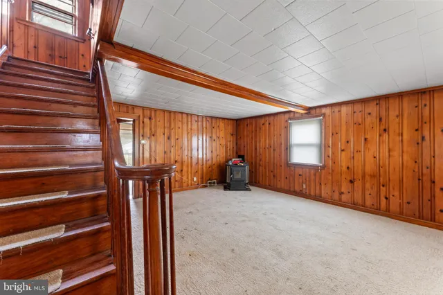 a view of an empty room with windows & entryway