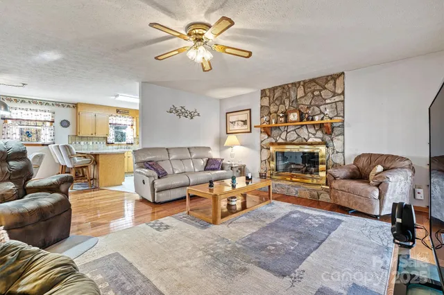 a living room with furniture a fireplace and a large window