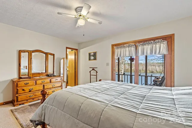 a bedroom with a large bed and a flat tv screen on dresser