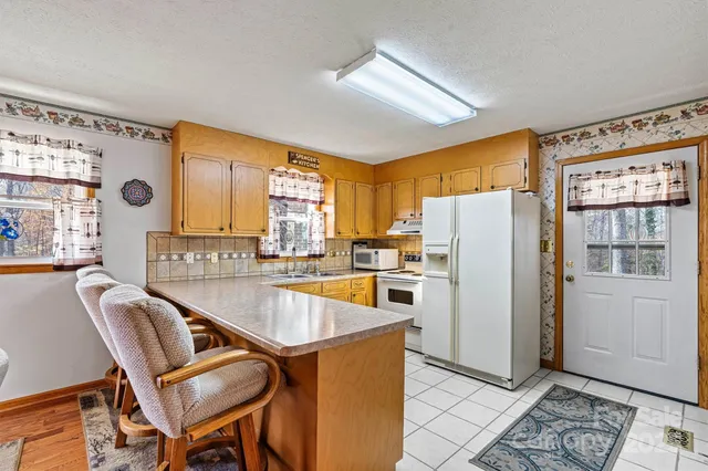 a kitchen with refrigerator a table and chairs