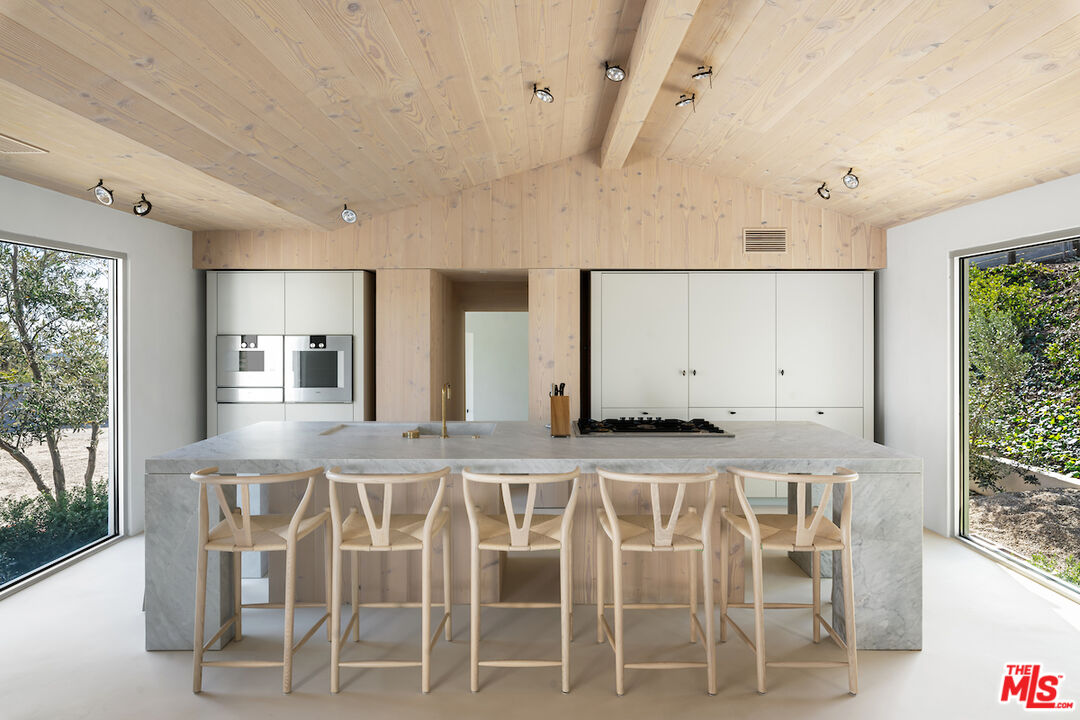 29500 Heathercliff Road, Unit 211 Malibu, CA 90265 - Photo 12 of 41 a kitchen with a table and chairs in it