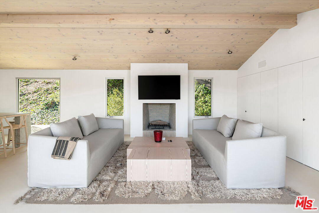 29500 Heathercliff Road, Unit 211 Malibu, CA 90265 - Photo 26 of 41 a living room with furniture a flat screen tv and a fireplace