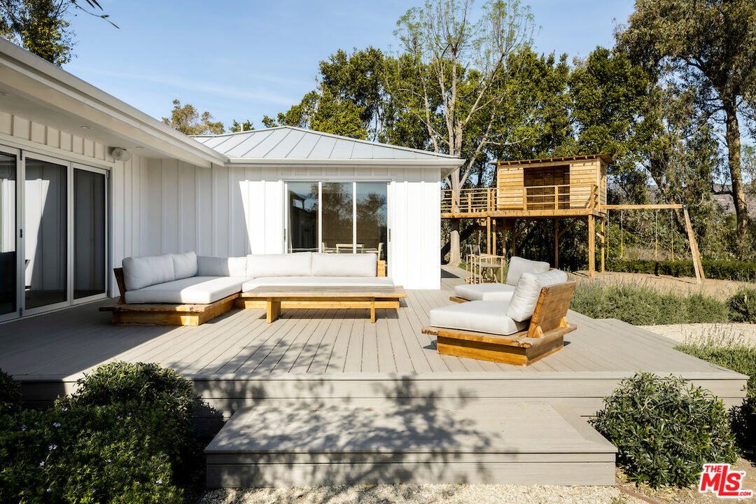 29500 Heathercliff Road, Unit 211 Malibu, CA 90265 - Photo 31 of 41 a view of a patio with couches table and chairs with wooden fence and plants