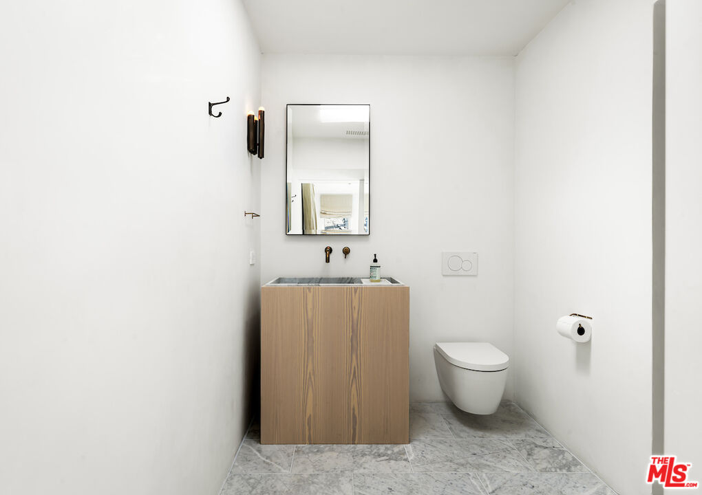 29500 Heathercliff Road, Unit 211 Malibu, CA 90265 - Photo 33 of 41 a bathroom with a toilet a sink and mirror