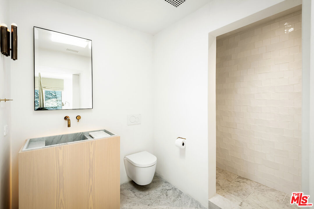 29500 Heathercliff Road, Unit 211 Malibu, CA 90265 - Photo 35 of 41 a bathroom with a toilet sink and mirror