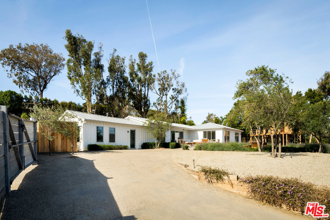 29500 Heathercliff Road, Unit 211 Malibu, CA 90265 - Photo 5 of 41 a front view of a house with a yard and trees