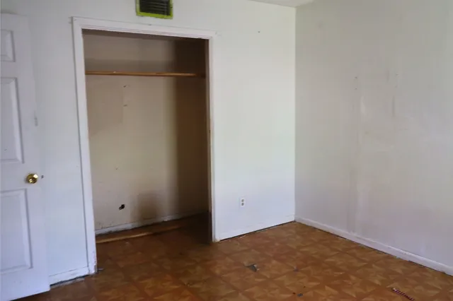 an empty room with closet and wooden door