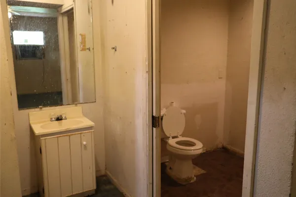 a bathroom with a toilet sink and mirror