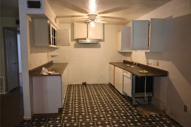 a kitchen with a sink a stove and cabinets