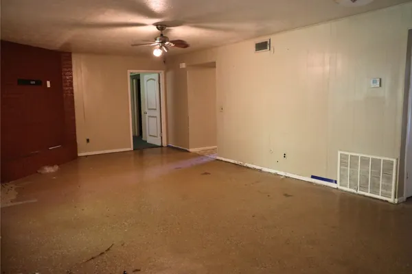 an empty room with closet and a chandelier fan