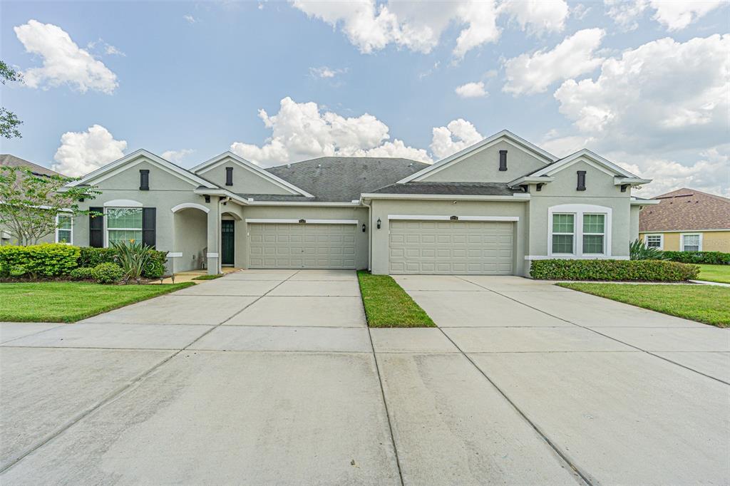 4256 Ashton Meadows Way Wesley Chapel, FL 33543 - Photo 11 of 42 a view of a white house with a large tree and a yard