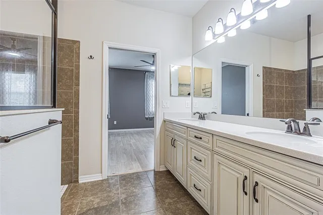 a spacious bathroom with a granite countertop sink a mirror and a shower
