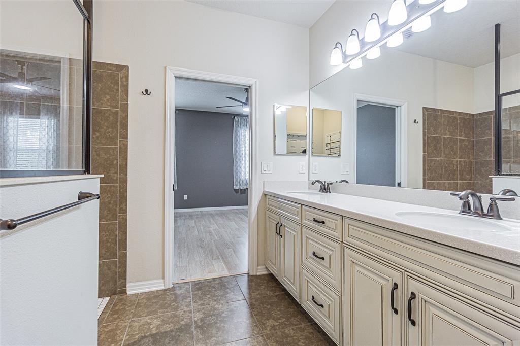 4256 Ashton Meadows Way Wesley Chapel, FL 33543 - Photo 13 of 42 a spacious bathroom with a granite countertop sink a mirror and a shower