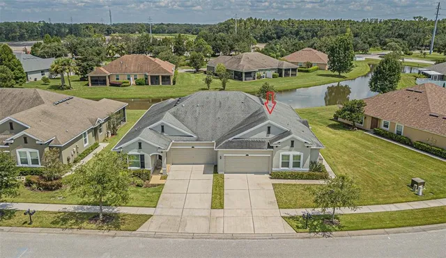 an aerial view of a house with swimming pool and green space