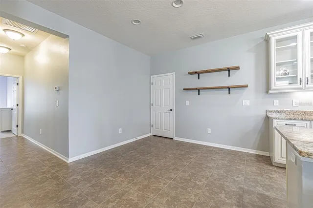 an empty room with windows and cabinet