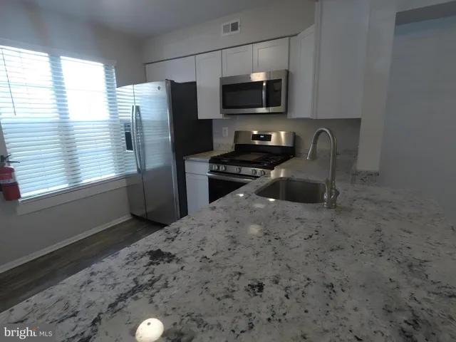 a kitchen with stainless steel appliances a refrigerator stove microwave and sink