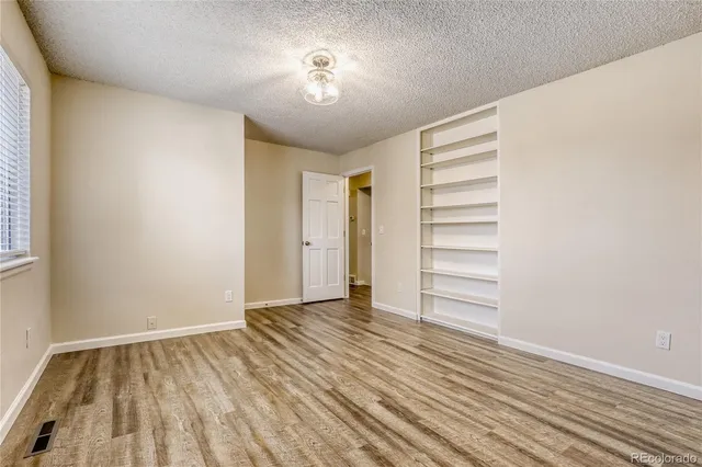 a view of room with window and wooden floor
