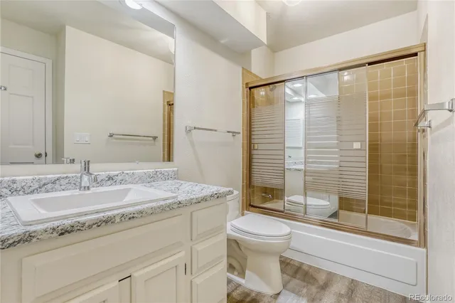 a bathroom with a granite countertop sink toilet and shower