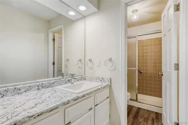 a bathroom with a granite countertop sink and a mirror