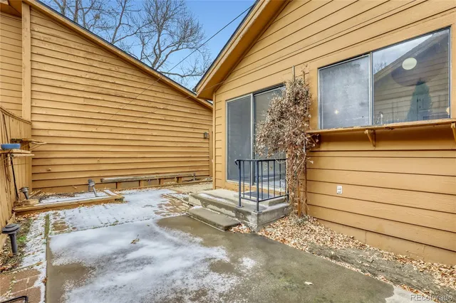 a small white building with a large window and brick walls