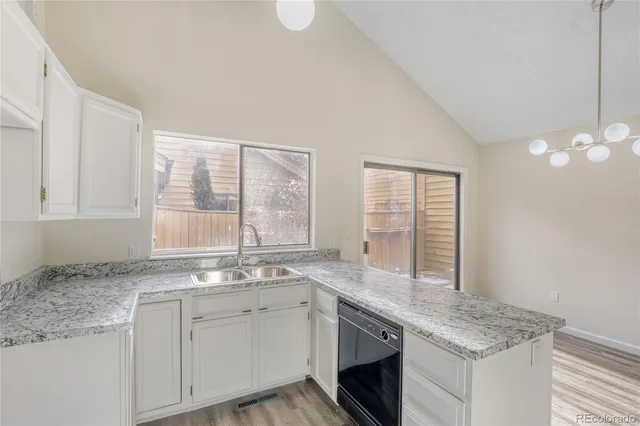 a kitchen with granite countertop a sink cabinets and window