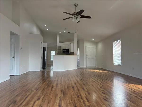 a view of empty room with wooden floor and window