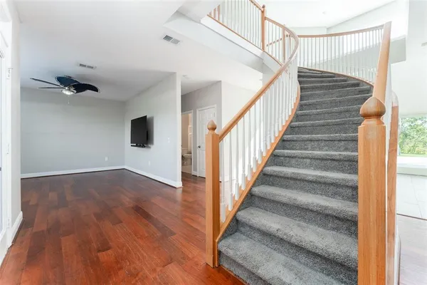 a view of staircase with wooden floor and white walls