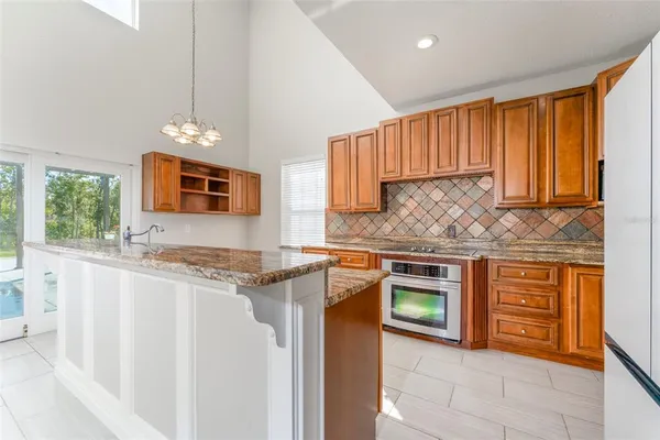 a kitchen with stainless steel appliances granite countertop a sink refrigerator and cabinets